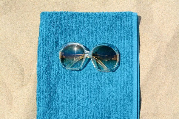 Miękki Niebieski Ręcznik Plażowy Okularami Przeciwsłonecznymi Piasku Widok Góry — Zdjęcie stockowe