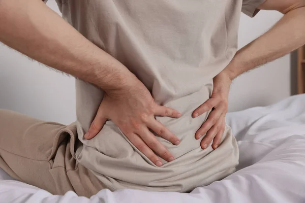 Man Suffering Back Pain While Sitting Bed Indoors Closeup Symptom — Stock Photo, Image