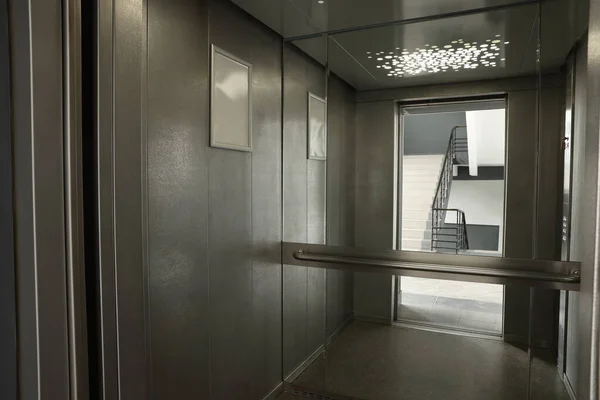 Open elevator`s cabin with big mirror indoors