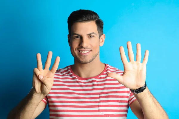 Man Showing Number Eight His Hands Light Blue Background — Stock Photo, Image