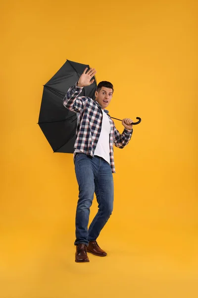 Hombre Emocional Con Paraguas Atrapado Ráfaga Viento Sobre Fondo Amarillo — Foto de Stock