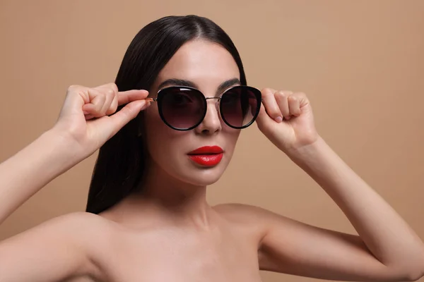 Atrakcyjna Kobieta Modnych Okularach Przeciwsłonecznych Beżowym Tle — Zdjęcie stockowe