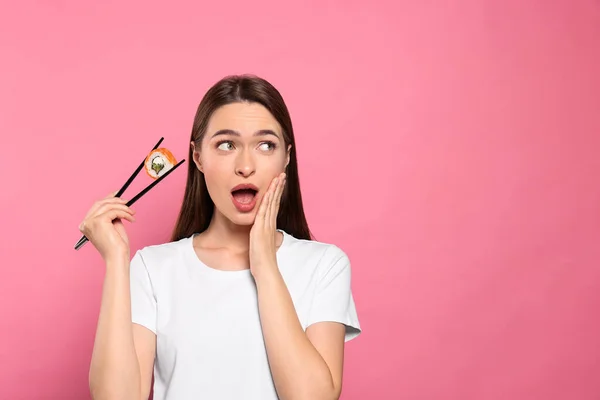 Emotionale Junge Frau Mit Sushi Rolle Und Essstäbchen Auf Rosa — Stockfoto