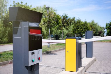 Güneşli bir günde modern yol bariyerleri ve parkmetre.