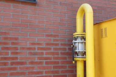 Kırmızı tuğla duvarın yanında sarı gaz borusu açık havada, metin için boşluk