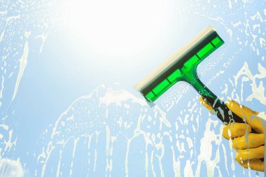 Person cleaning glass with squeegee , view from inside