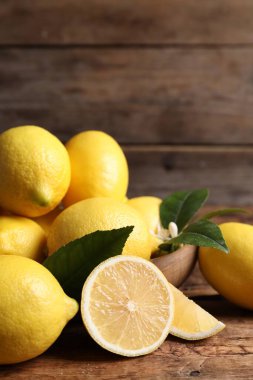 Tahta masada yeşil yapraklı taze limonlar.