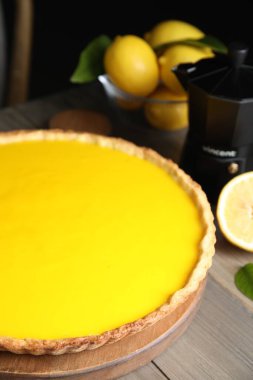 Delicious homemade lemon pie and fresh fruits on wooden table, closeup
