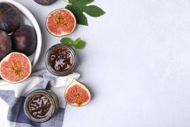Cam kavanozlar dolusu lezzetli incir reçeli ve ışık masasında meyveler, düz uzanma. Metin için boşluk
