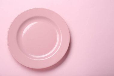 Pembe arka planda boş seramik plaka, üst manzara. Metin için boşluk