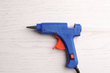 Koyu mavi tutkal tabancası beyaz ahşap masa, üst manzara