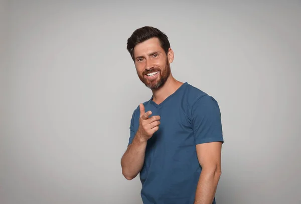 Hombre Barbudo Sonriente Apuntando Hacia Adelante Con Dedo Sobre Fondo —  Fotos de Stock