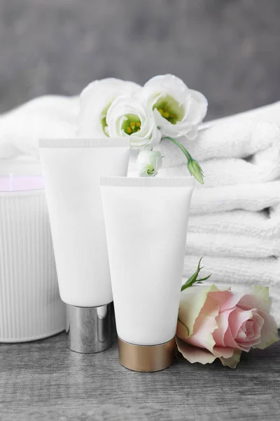 Kosmetikprodukte Duftkerzen Und Gefaltete Handtücher Mit Blumen Auf Holztisch Drinnen — Stockfoto