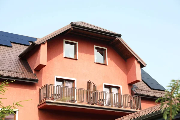 View of house with balconies and solar panels on roof