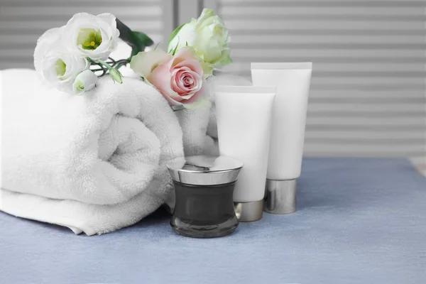 Handtücher Kosmetikprodukte Und Blumen Auf Grauem Tisch Drinnen — Stockfoto