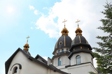 Bulutlu gökyüzüne karşı altın kubbeleri olan güzel kilise