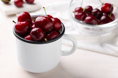 Fresh ripe cherries with water drops on white wooden table, closeup