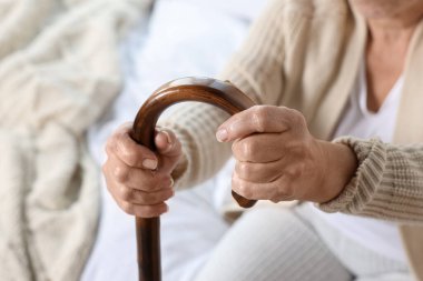 Elderly woman with walking cane indoors, closeup. Home care service