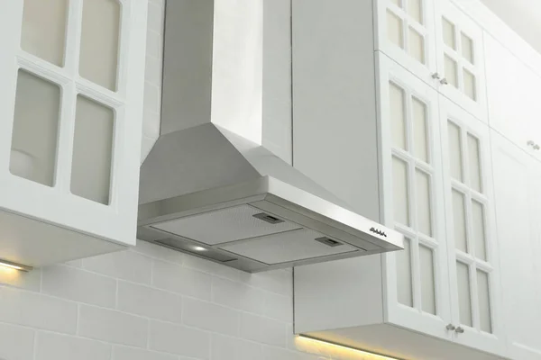 Modern range hood on white brick wall in kitchen