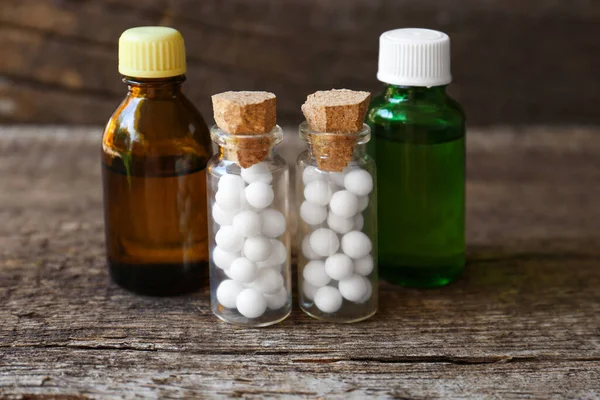 Bottles with homeopathic remedy on wooden stump