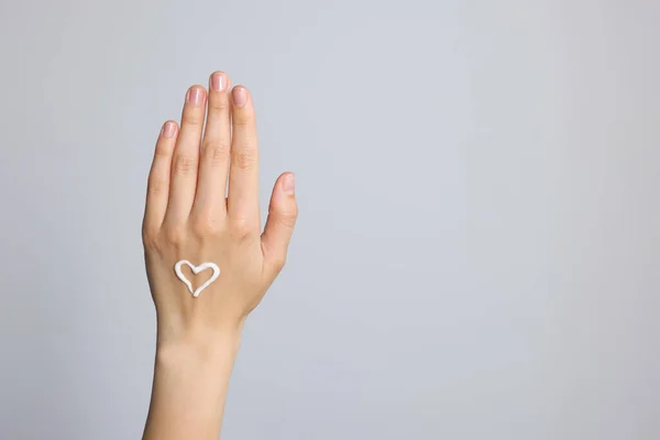 Καρδιά Βαμμένη Κρέμα Στο Χέρι Ανοιχτό Γκρι Φόντο Κοντινό Πλάνο — Φωτογραφία Αρχείου