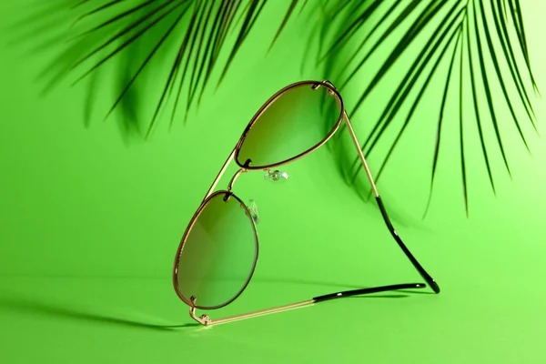 Yeşil Zemin Üzerinde Şık Güneş Gözlükleri Palmiye Dalları — Stok fotoğraf