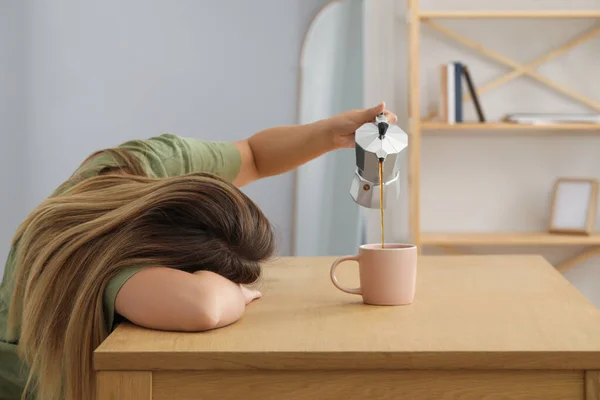 Ύπνος Γυναίκα Ρίχνει Καφέ Στο Κύπελλο Στο Ξύλινο Τραπέζι Εσωτερικούς — Φωτογραφία Αρχείου