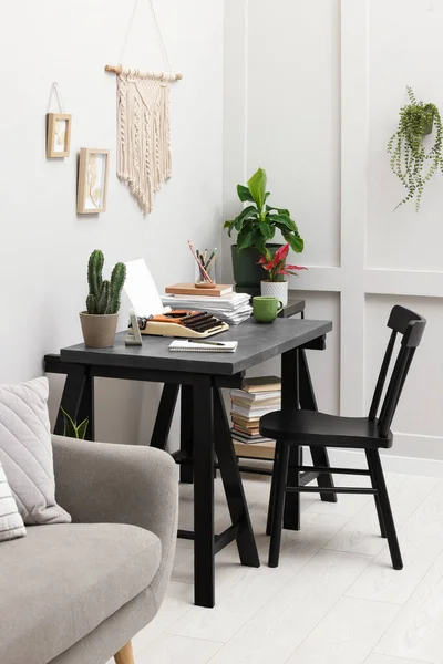 Typewriter and stack of papers on dark table in room. Writer's workplace