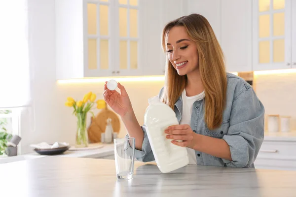 Junge Frau Gießt Milch Aus Gallone Flasche Glas Weißem Marmortisch — Stockfoto