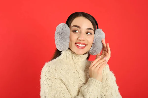 Hermosa Mujer Joven Con Orejeras Sobre Fondo Rojo — Foto de Stock