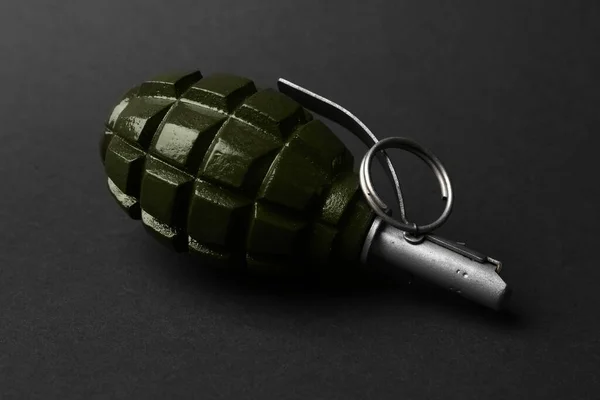 Hand grenade on black background, closeup. Explosive weapon