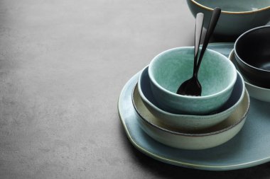 Gri masada boş bulaşık takımları ve çatal bıçaklar, metin için boşluk