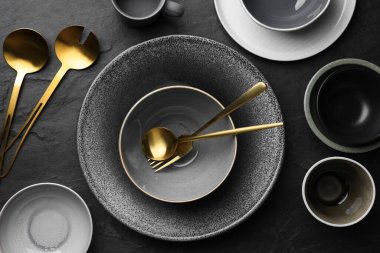 Set of clean tableware on black table, flat lay