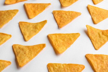 Tasty tortilla chips (nachos) on white background