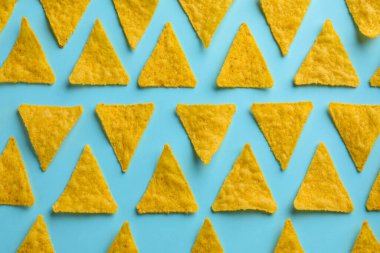 Açık mavi zemin üzerinde lezzetli tortilla cipslerinin (nachos) düzleştirilmiş bileşimi