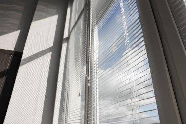 Odada yatay jaluzili, düşük açılı pencereler