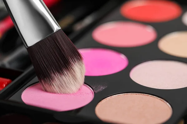 Colorful eyeshadow palette with brush, closeup view