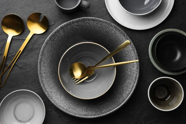 Set of clean tableware on black table, flat lay