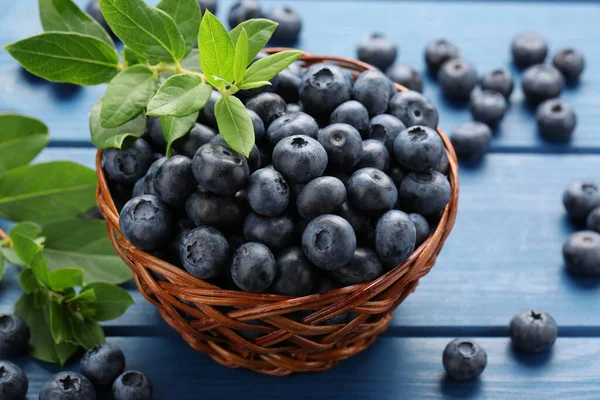 Tasty Fresh Blueberries Green Leaves Blue Wooden Table Closeup — Stockfoto