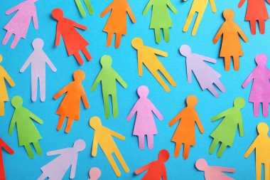 Many different paper human figures on light blue background, flat lay. Diversity and inclusion concept