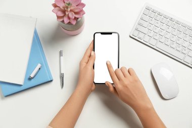 Beyaz masada akıllı telefon kullanan kadın, üst görünüm
