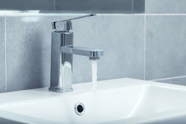 Banyodaki musluktan akan su akıntısı