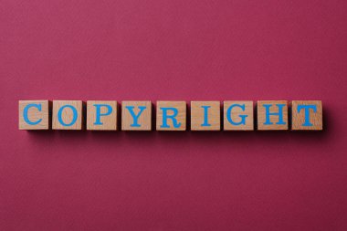 Koyu pembe arka planda telif hakkı olan tahta küpleri düz yatıyordu. İntihal konsepti