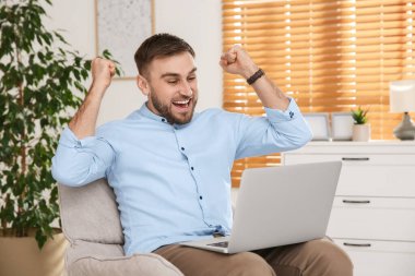 Evde dizüstü bilgisayar kullanarak online müzayedeye katılan duygusal adam.