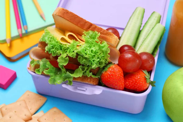 Lunchbox Smacznym Jedzeniem Szkolną Papeterią Jasnoniebieskim Tle Zbliżenie — Zdjęcie stockowe