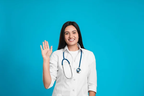 Šťastná Žena Lékař Mává Pozdravit Světle Modrém Pozadí — Stock fotografie