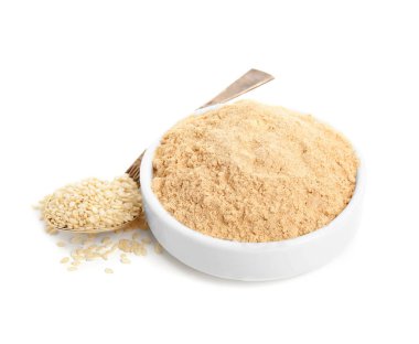 Seramik kasede susam unu ve beyaz üzerine izole edilmiş tohumlar.