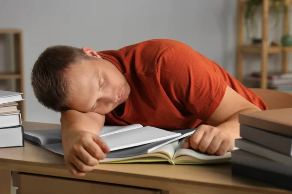 Moe Man Slapen Buurt Van Boeken Aan Houten Tafel Binnen — Stockfoto