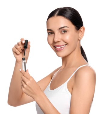 Beyaz arka planda kirpik yağı olan genç bir kadın.