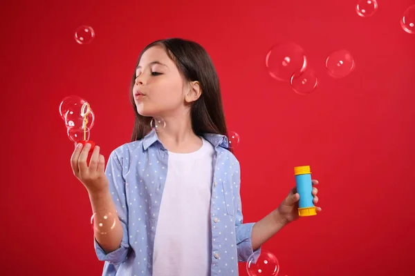 Malá Dívka Foukání Mýdlo Bubliny Červeném Pozadí — Stock fotografie